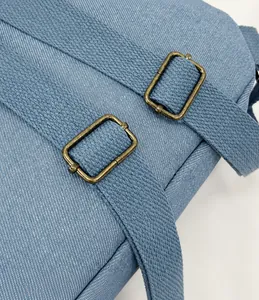Close-up of smooth adjustable shoulder straps with bronze metal buckles on blue backpack