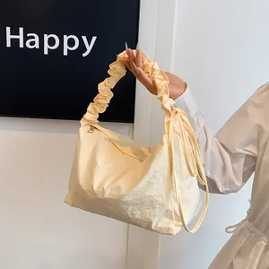 Schicke cremegelbe Canvas-Schultertasche mit Faltenhenkel und seitlicher Kordelzug-Schleife