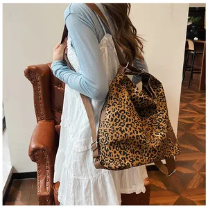 Close-up of leopard print canvas tote bag with adjustable brown strap and metal buckle