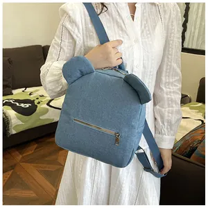 Detail showing the light blue denim backpack fabric with cute 3D bear ear design features