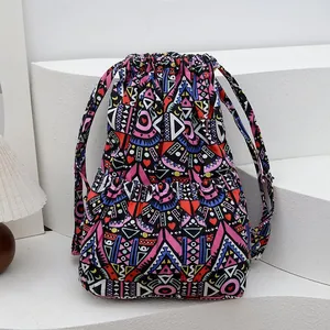 Detail of drawstring bucket bag showing vibrant ethnic geometric patterns and fabric texture