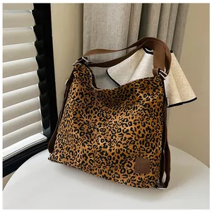 Detail of leopard print canvas bag with durable brown nylon strap and leather brand label