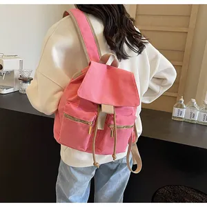 Vista trasera de una mochila tipo cubo de lona rosa con correas dobles y cremalleras
