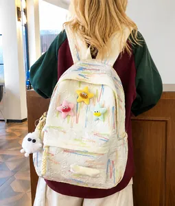Quilted white backpack with colorful embroidery and three plush star charms on front