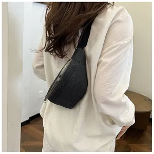 Close-up of a casual dark grey denim chest bag with metal zipper and adjustable strap