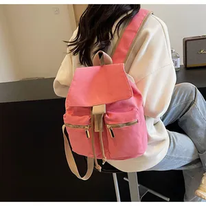 Vista trasera de una mochila tipo cubo de lona rosa con doble cremallera y correas
