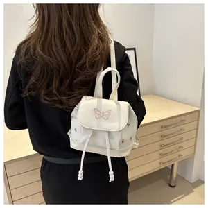 Detail of white PU leather mini backpack with pink butterfly and floral embroidery