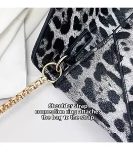 Detail of golden ring link and chain strap on leopard print crossbody bag