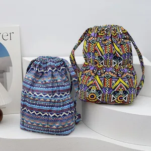 Close-up of ethnic drawstring backpacks with colorful geometric patterns and side pockets