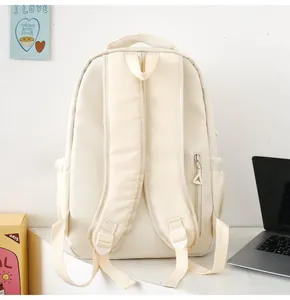 Detailed back view of a cream backpack showing padded straps and a hidden anti-theft pocket