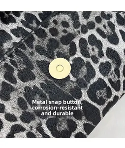 Close-up of leopard print clutch with durable gold magnetic snap and woven texture detail