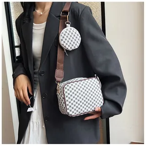 Detail view of cream crossbody camera bag with geometric print and a wide shoulder strap