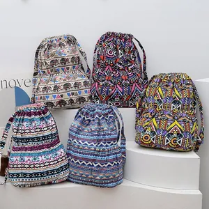 Detail of five ethnic style drawstring backpacks with colorful bohemian patterns on canvas