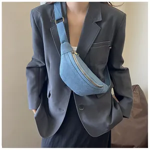 Blue denim crossbody bag featuring adjustable woven strap and gold-tone metal zipper details