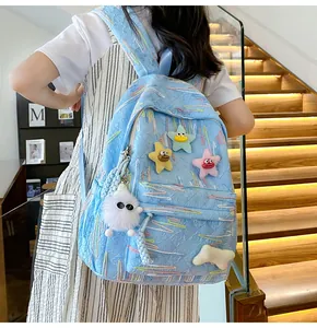 Detail of light blue backpack with quilted texture and colorful plush star charms