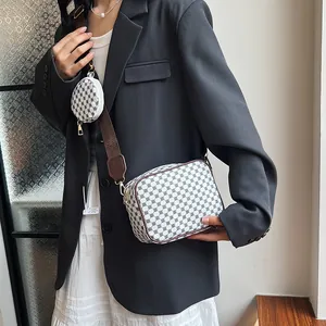 Retro messenger bag with geometric pattern and wide strap shown on a fashion model