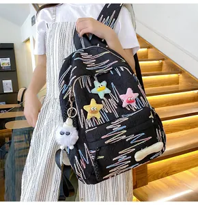 Detail of black backpack featuring crinkle texture, wavy embroidery and plush star charms