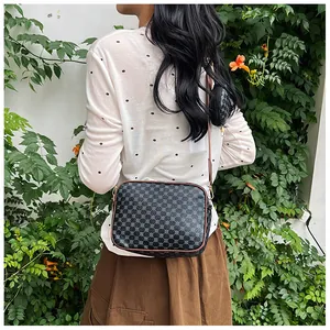 Detail of vintage geometric print crossbody bag with a round coin pouch on a wide strap