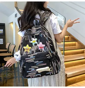 Rear view of black jacquard backpack with colorful embroidery and plush star charms