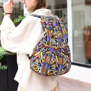 Close-up of ethnic striped drawstring backpack with colorful geometric patterns on model