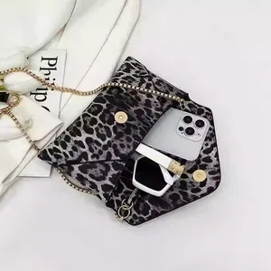 Leopard print envelope handbag with gold chain strap holding a phone and sunglasses