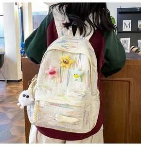 Detail of white canvas backpack with colorful star plushies and cute embroidery accents