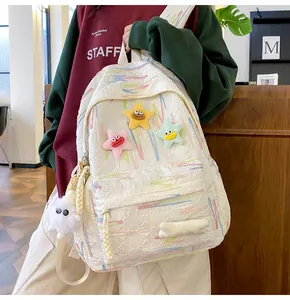 Detail of white Japanese school backpack featuring colorful stripes and cute plush star charms