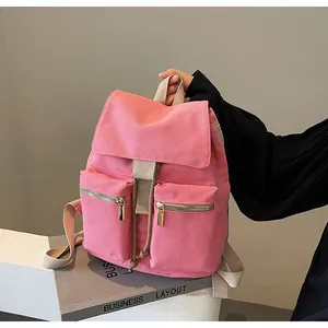 Mochila de lona rosa con cierre de cordón y dos bolsillos frontales con cremallera detalle