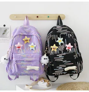 Detail of cute Japanese style backpacks with wavy embroidery and plush ball charm