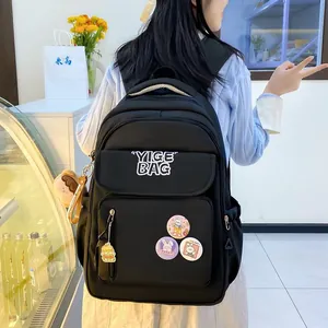 Detail of black nylon backpack with multi-pocket design and cute rabbit pin ornaments