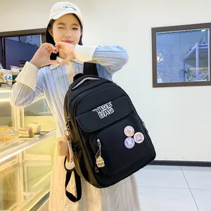 Detail of black nylon backpack with cute burger pendant and decorative rabbit pins