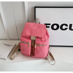 Detalle de la mochila de lona rosa con bolsillos delanteros y cierre de cordón