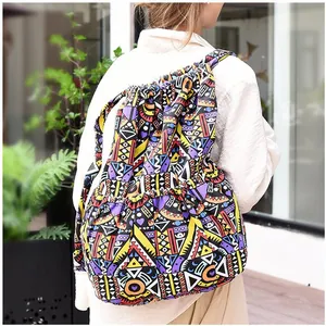 Ethnic striped drawstring backpack with vibrant geometric patterns on a casual model