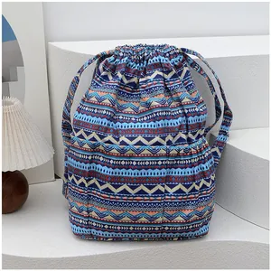 Close-up of geometric ethnic drawstring bucket bag with colorful striped canvas and side pocket