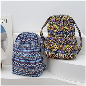 Detail of colorful geometric canvas backpacks showing drawstring closure and fabric texture