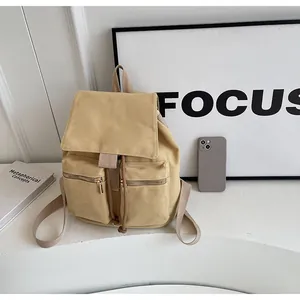 Detalle macro de mochila de lona caqui con bolsillos dobles y cierre de solapa