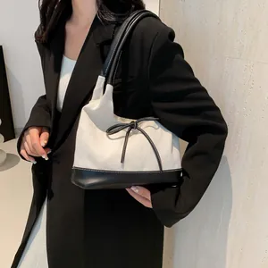 Contrast black and white tote bag with bow detail, shown on model for daily commuting
