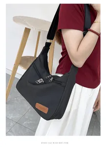 Detail of black waterproof oxford fabric crossbody bag with multi-zipper pockets