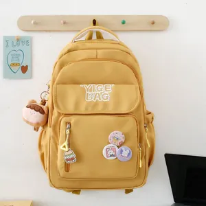 Large yellow waterproof canvas school backpack with cute rabbit badges and plush charms
