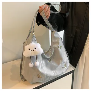 Détail du sac à bandoulière argenté avec papillons et pendentif nuage en peluche