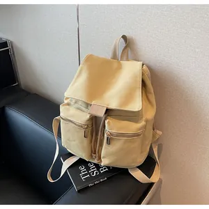 Detalle de la mochila de lona beige con tejido de alta densidad y cremalleras de metal dorado