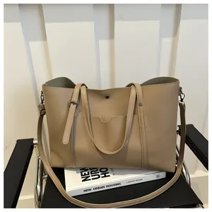 Detail view of light brown PU leather tote bag with front pocket and adjustable strap