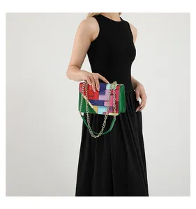 Detail view of a geometric color-block chain bag with vibrant artistic patchwork patterns