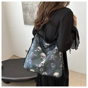 Close-up of a large nylon tote bag featuring a green skull and floral print and logo strap