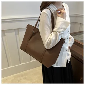 Detail of soft dark brown leather tote bag with decorative stitching and shoulder strap