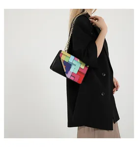 Detail of a chic crossbody square bag with colorful geometric patchwork and gold chain
