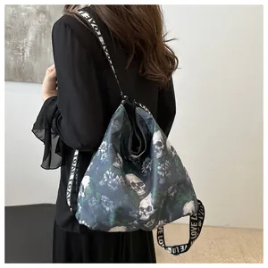 Detail of waterproof nylon crossbody bag featuring skull floral print and LOVE strap