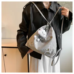 Détail du sac cabas argenté papillon avec breloque peluche et bandoulière réglable