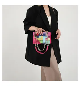 Detail view of colorful geometric patchwork shoulder bag with chunky gold chain strap