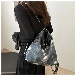 Detailed shot of large nylon tote bag featuring skull and floral print with LOVE strap